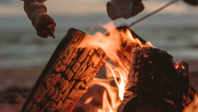 Stockbrot wird auf einem Lagerfeuer gegrillt.